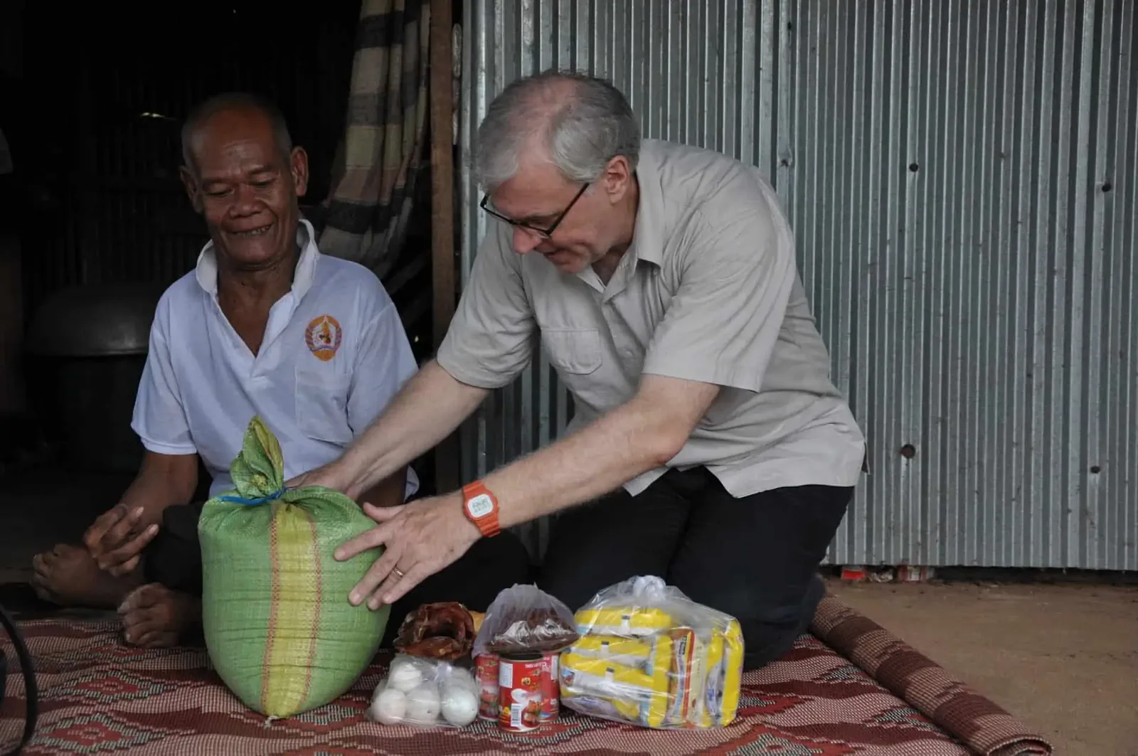 Paul meeting one of the elderly, who is disabled, and giving food to him.